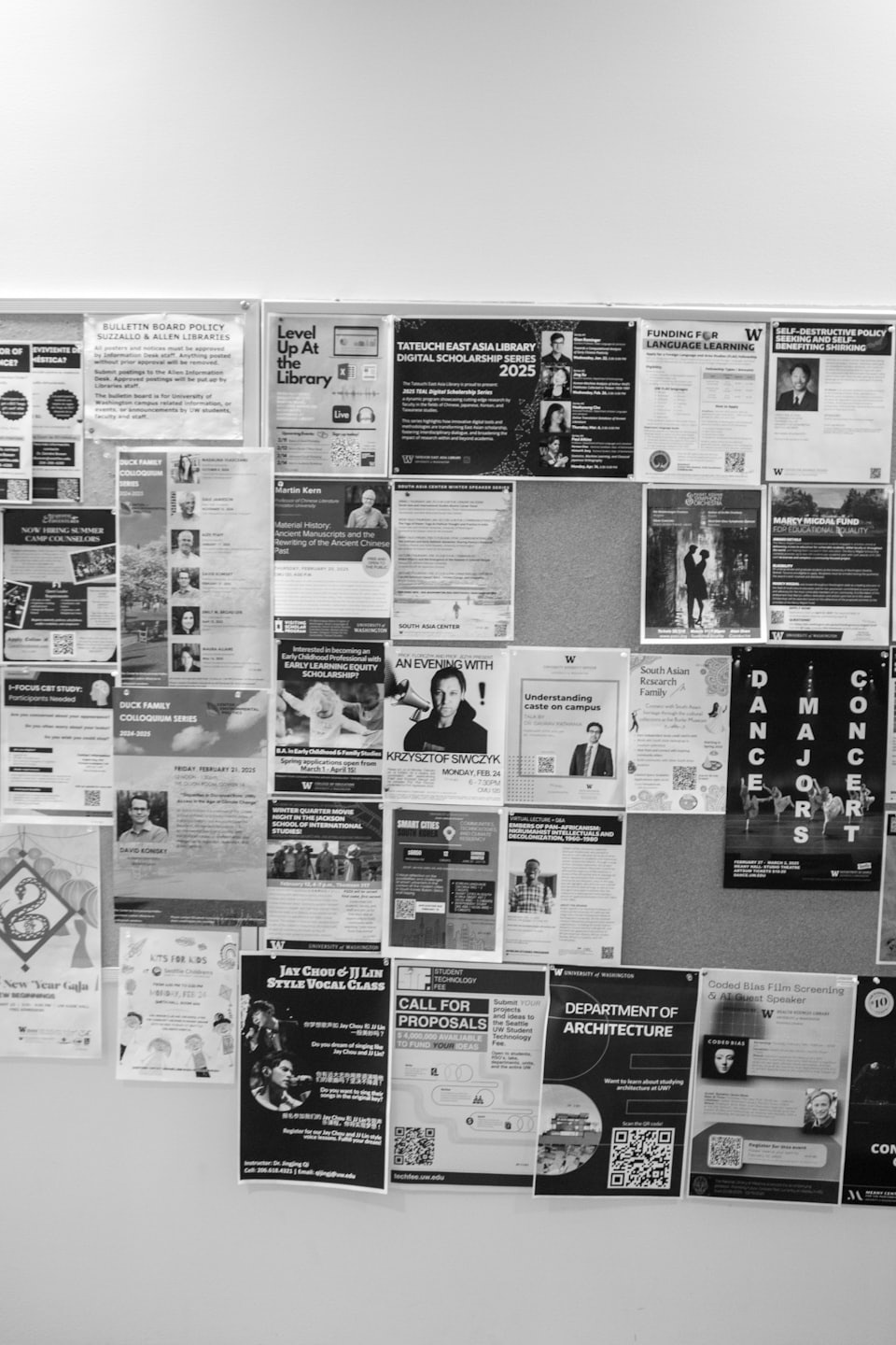 Tablica ogłoszeń pokryta wieloma nachodzącymi na siebie plakatami i ulotkami.